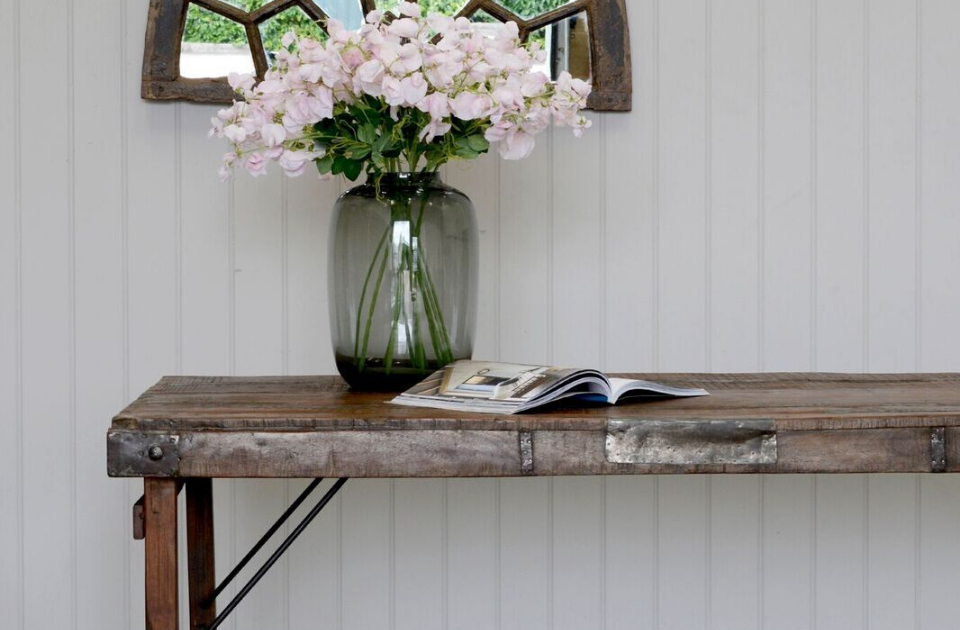 A vase with flowers on top of a dining table. 