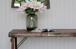 A vase with flowers on top of a dining table. 