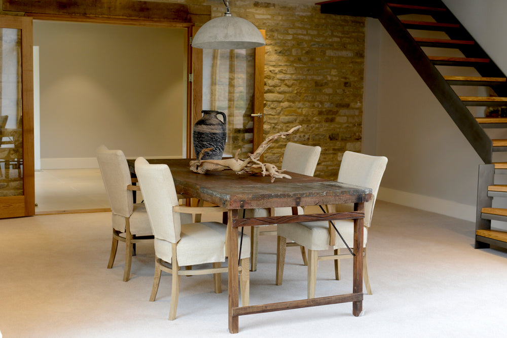 A wooden table surrounded by four wooden and cream leather chairs 
