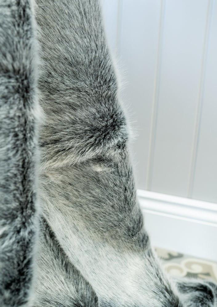 Close up detail of faux fur throw in grey