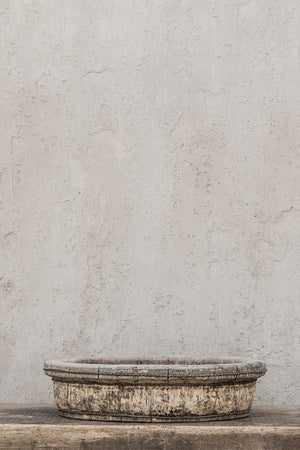 Close up of tin based shallow tea pickers bowl with wooden rim.