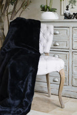 Faux fur throw in black over grey dining chair